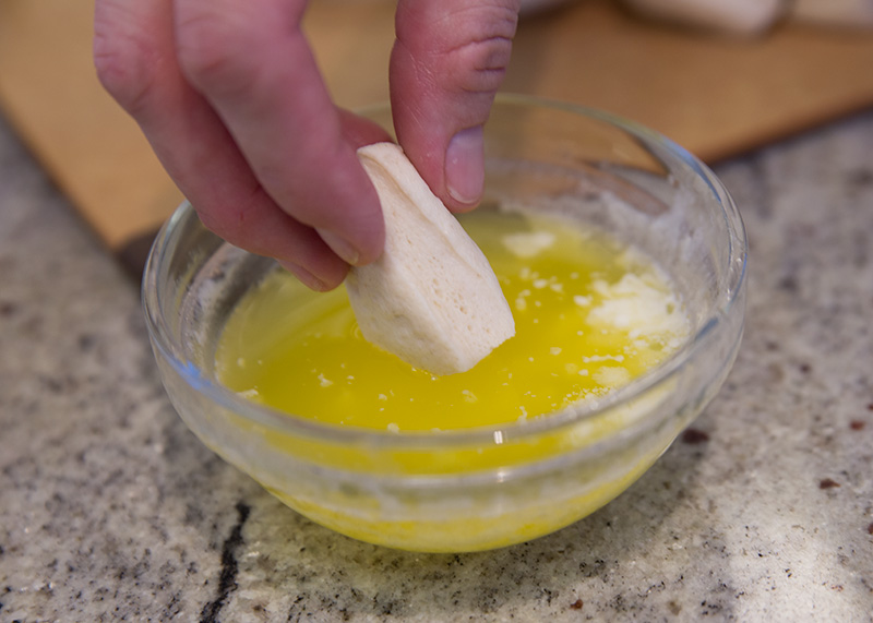 dip biscuit quarters into melted butter