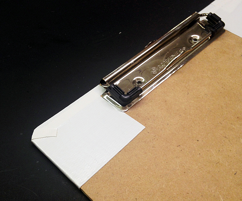 cover the front of the clipboard with white tape